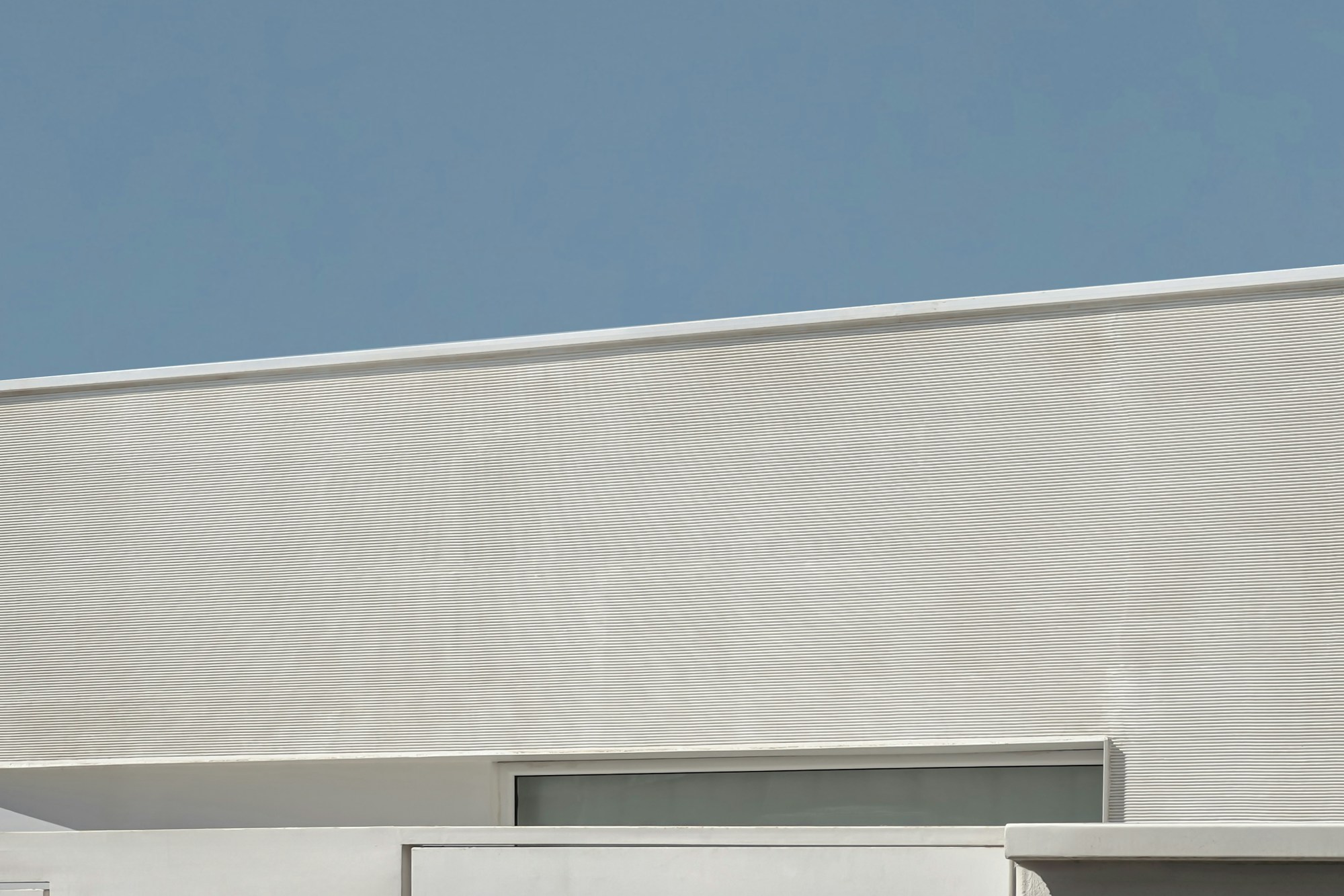 Geschlossene moderne Fassade mit klaren Linien und geometrischen Fenstern