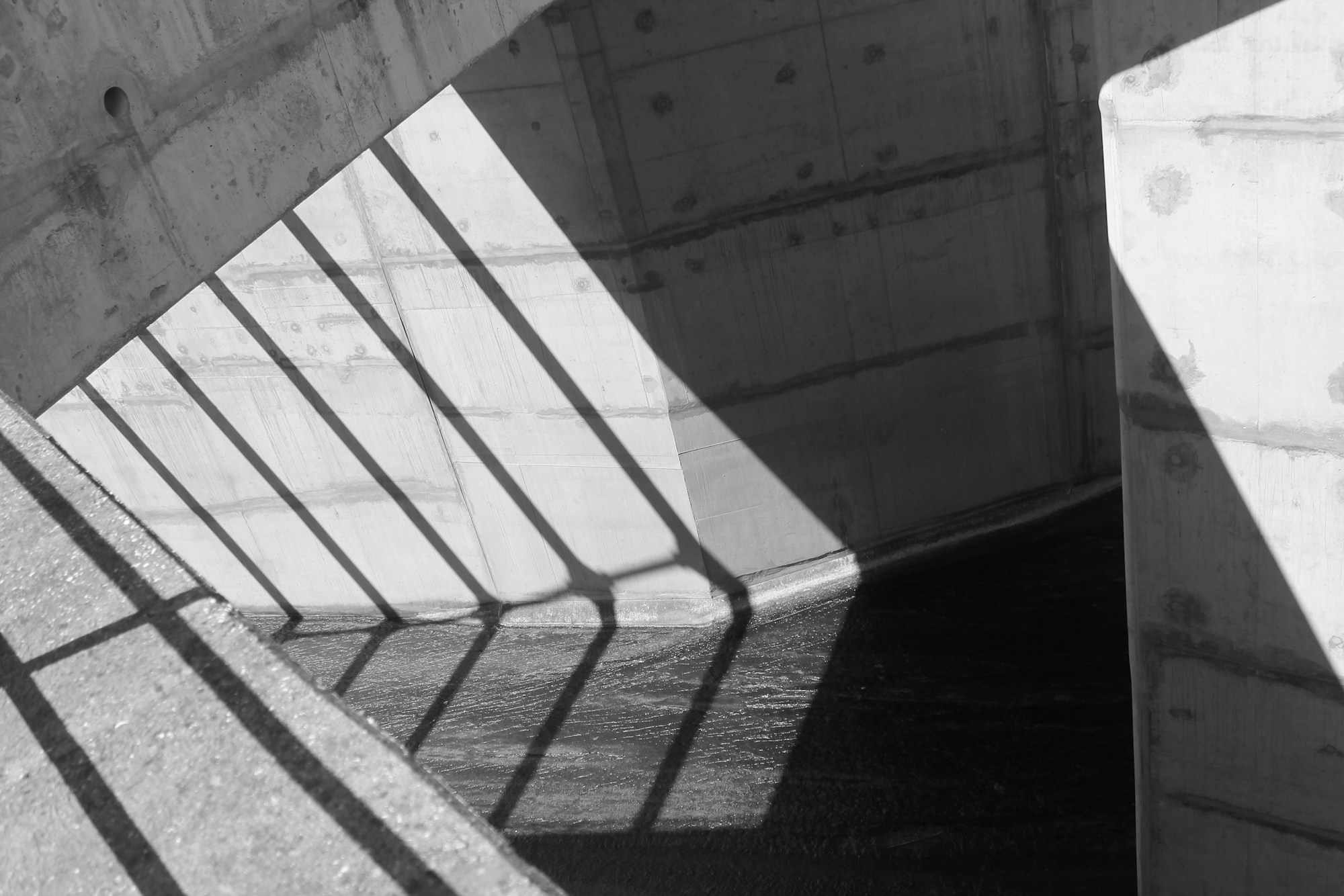 Architecture géométrique en béton, jeux d'ombre et de lumière sur des lignes épurées