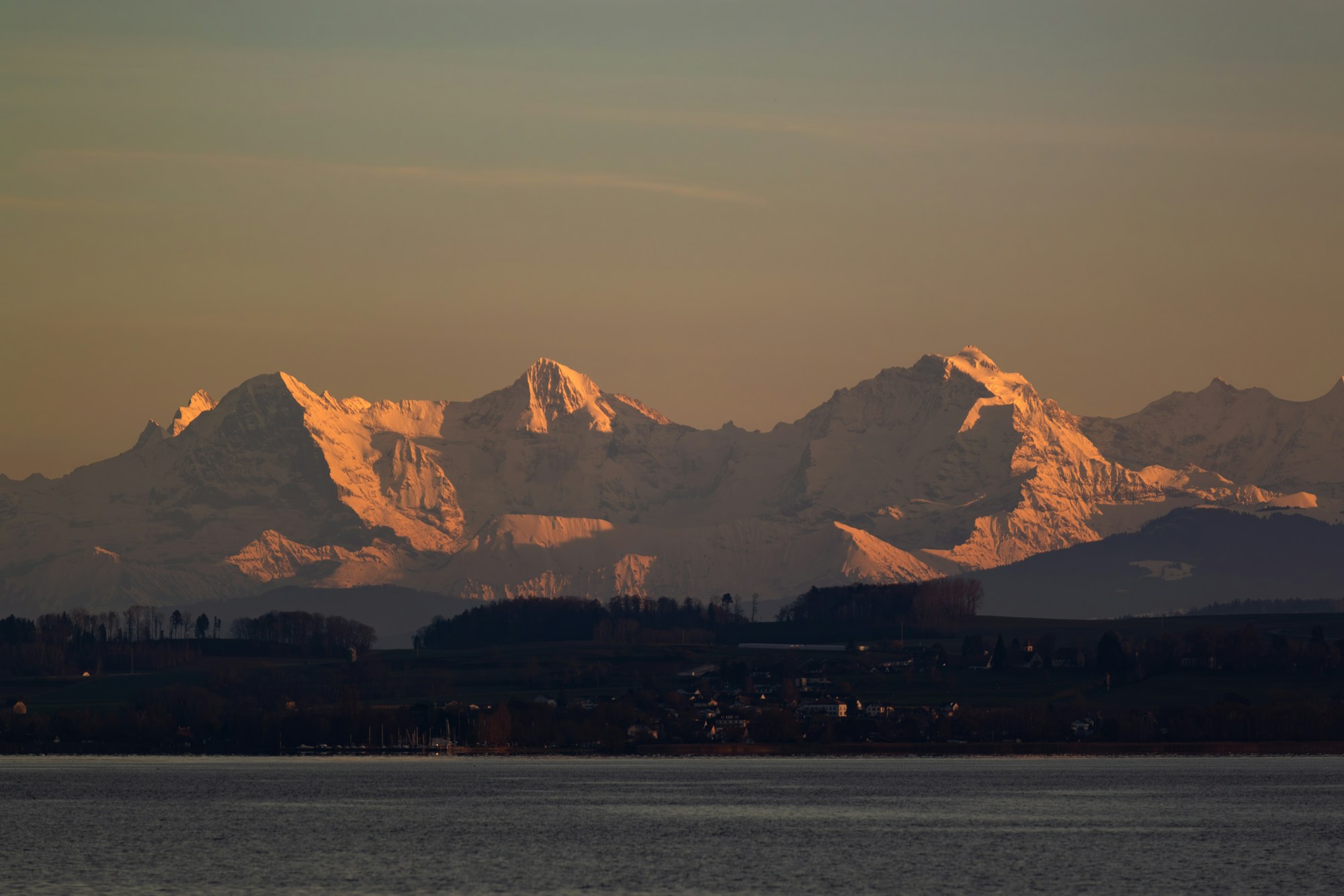 Calm surface of a Swiss lake at early morning, open horizon