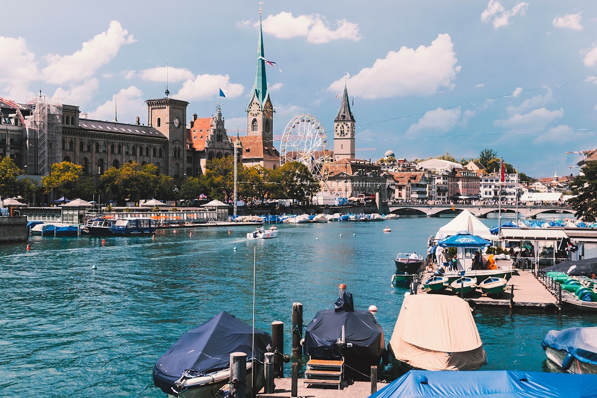 Vue sur la Limmat à Zurich avec clochers, pont et bateaux amarrés le long de la rive