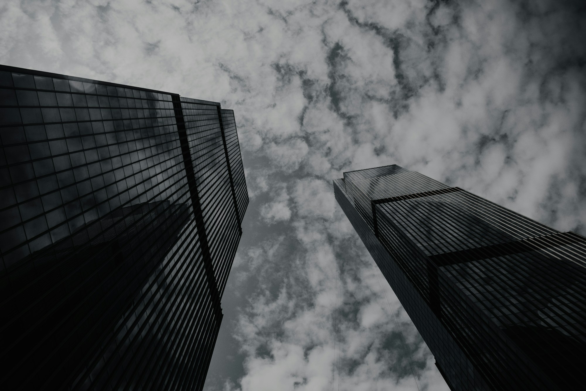 Two symmetrical modern towers reflecting under a clear sky