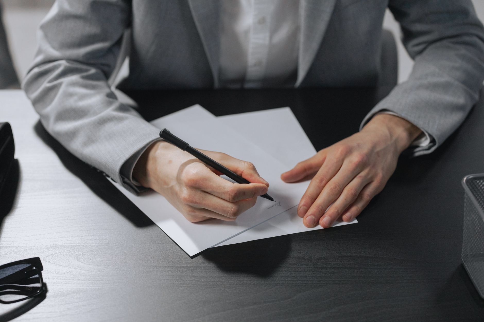 A hand signing a document in an office