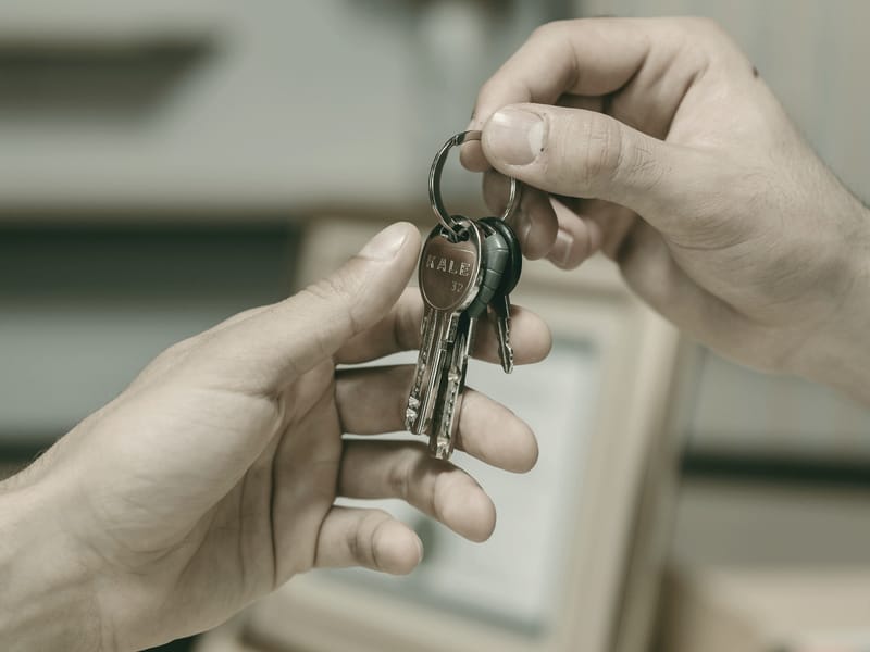 Ein Schlüsselbund geht von einer Hand in die andere