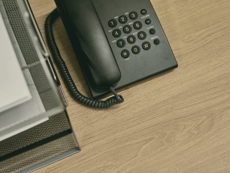 A desk telephone next to a document tray.